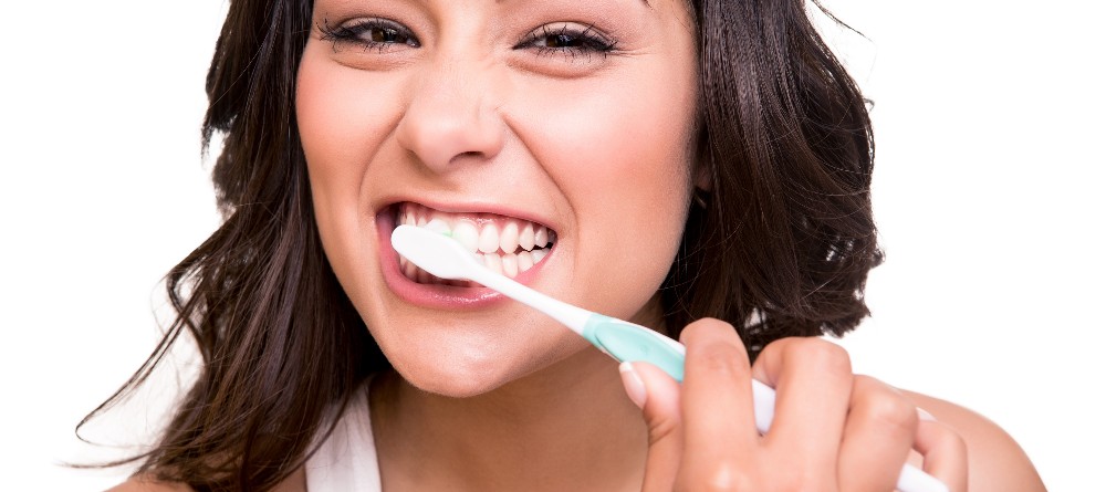 Woman brushing her teeth to prevent tooth decay
